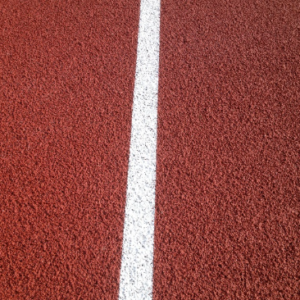 Polymeric rubber sports surfacing installed within a multi use games area