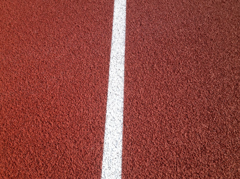 Polymeric rubber sports surfacing installed within a multi use games area